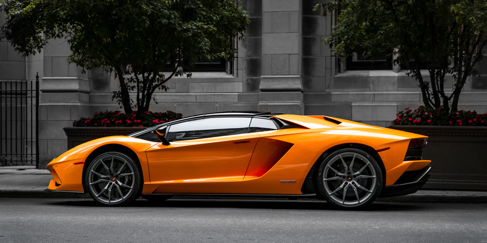 Orange Lamborghini Aventador parked on a city street