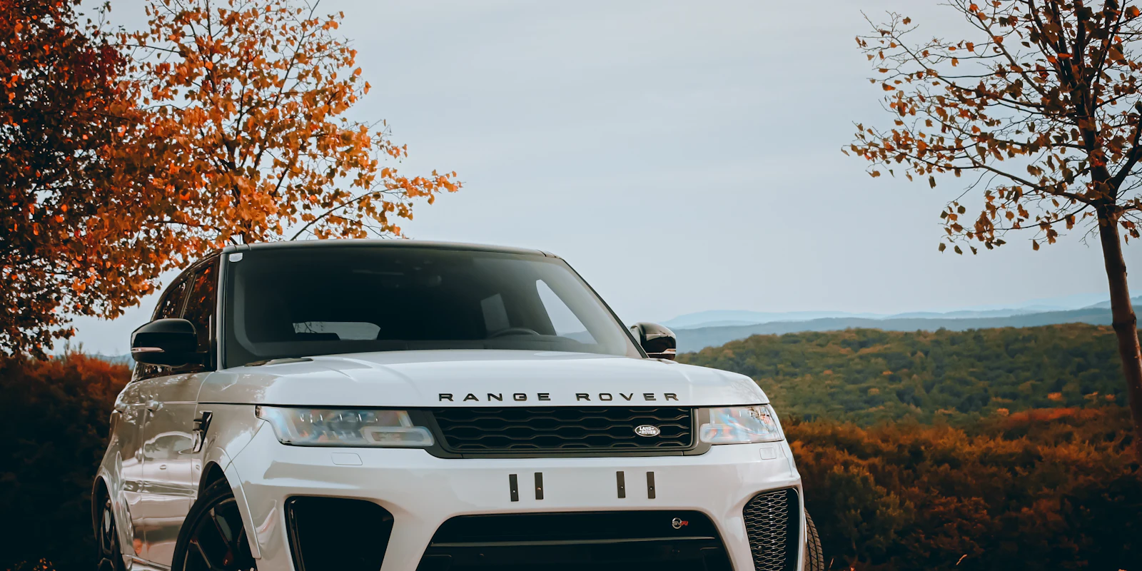 White Range Rover Sport in autumn
